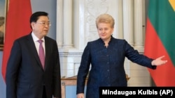 Тодішня президентка Литви Даля Ґрибаускайте (праворуч) вітає голову Національного з’їзду Китаю Чжана Децзяна перед їхньою зустріччю у Вільнюсі у квітні 2017 року