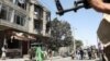 Taliban fighters stand guard at the site of a deadly attack on a Sikh temple in Kabul on June 18.