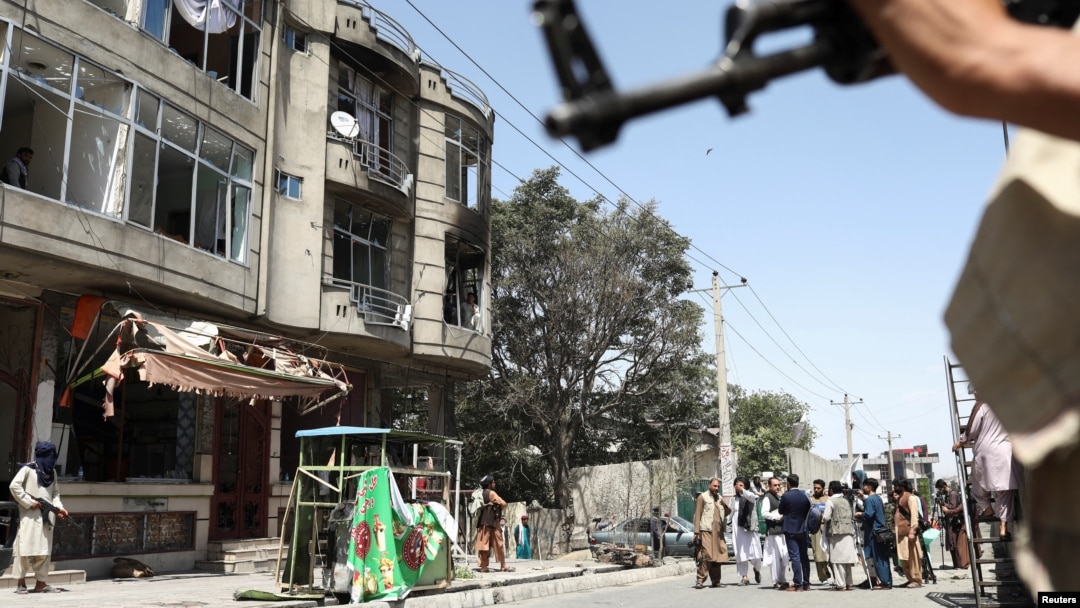 Taliban fighters stand guard at the site of a deadly attack on a Sikh temple in Kabul on June 18.