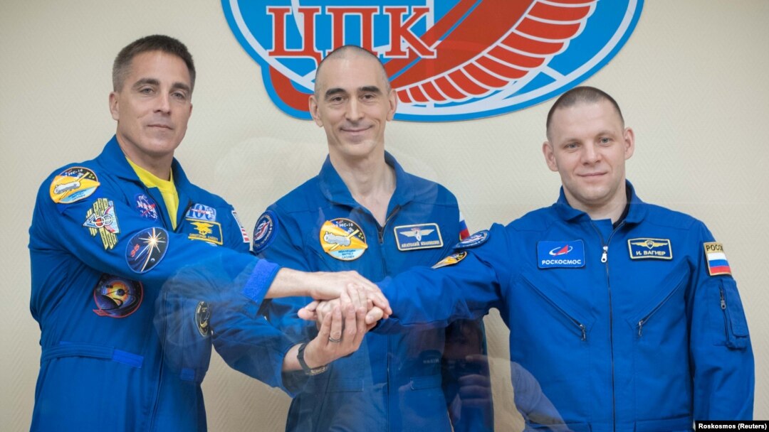 Crew members Chris Cassidy of NASA (left to right) and Anatoly Ivanishin and Ivan Vagner of Roskosmos pose for a picture behind a glass wall during a final news conference ahead of their mission to the International Space Station in Baikonur on April 8.