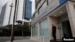 A security guard stands in front of a closed branch of Russian Commercial Bank in Nicosia, Cyprus on March 19.