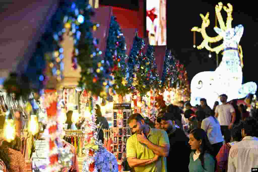 Cumpărătorii vizitează tarabele dintr-o piață amenajată într-un centru comercial, înaintea sărbătorilor de Crăciun, în Bengaluru, India, pe 13 decembrie 2025.