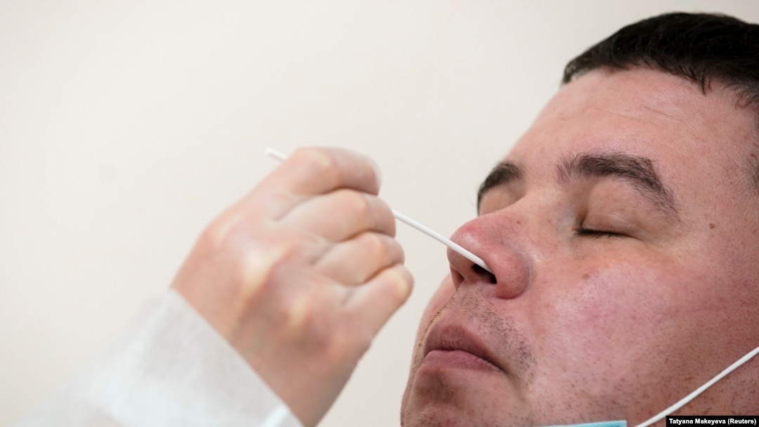 RUSSIA -- A health worker wearing protective gear takes a swab from a man to test for the coronavirus disease (COVID-19) at clinic in Moscow, Russia October 1, 2020. 