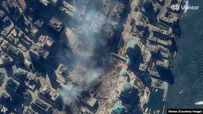 The site of the World Trade Center in New York City seen on September 15, 2001, as smoke rises from the September 11 attacks.The 2026 image of the rebuilt site was captured on June 25.
