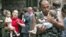 A soldier carries a baby and a woman follows him with another small child after the release of 26 women and their children in Beslan on September 2, 2004.