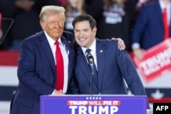 Donald Trump greets Marco Rubio at a campaign rally in Raleigh, North Carolina, on November 4.