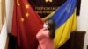 CHINA – A visitor to a Ukraine restaurant holds together the Chinese and Ukraine national flags as she poses for a photo. Beijing, Feb. 24, 2022 