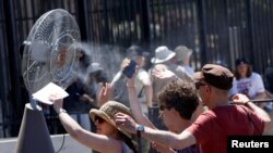 Disa njerëz duke u freskuar në Romë, më 30 qershor 2025.