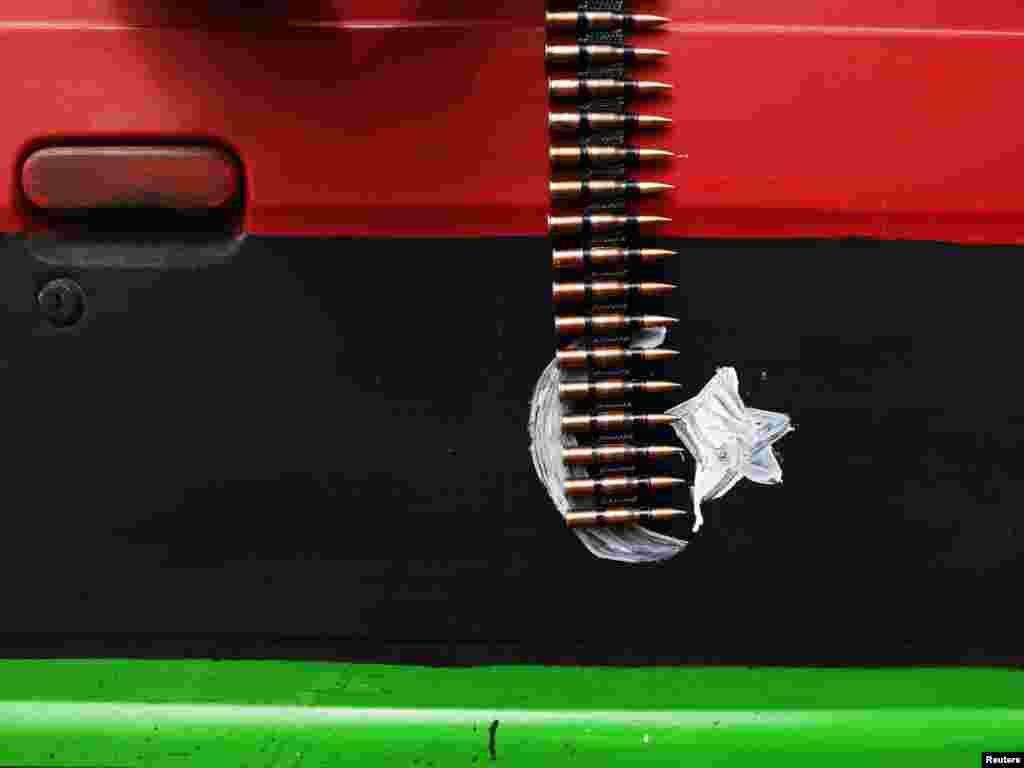 An ammunition belt hangs over a car door painted in the colors of the rebel Kingdom of Libya flag near Brega in eastern Libya on March 30. Photo by Finbarr O'Reilly for Reuters