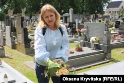 Ганна прибирає сміття з могили воїнів УГА