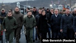 Ukrainian President Volodymyr Zelenskiy (3rd left) visits a section of the restored bridge in the settlement of Stanytsya Luhanska on November 20.