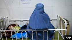 هرات کې یوه افغان ښځه د خپل ناروغ ماشوم سره 