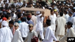 Ahmadi community members carry a coffin during a funeral ceremony in 2010 for victims of a militant attack on one of the sect's prayer halls, which killed some 80 people. According to a new report by the U.S. State Department, the religious minority Ahmadis are still the target of frequent sectarian violence.