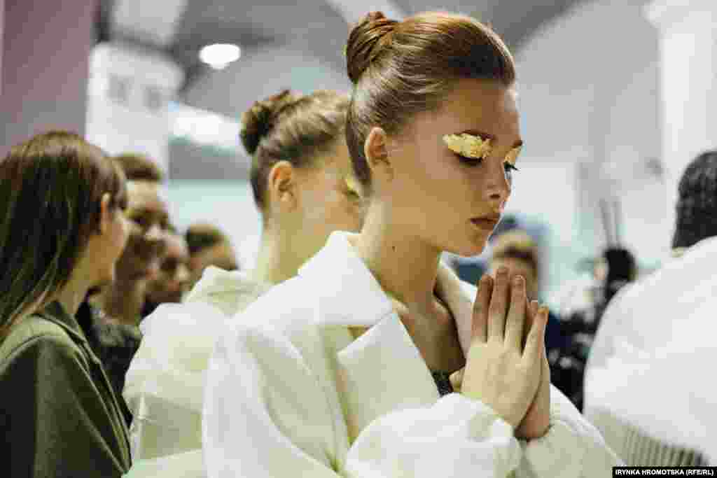 A model composes herself during Ukrainian Fashion Week in Kyiv. (RFE/RL/Irynka Hromotska)