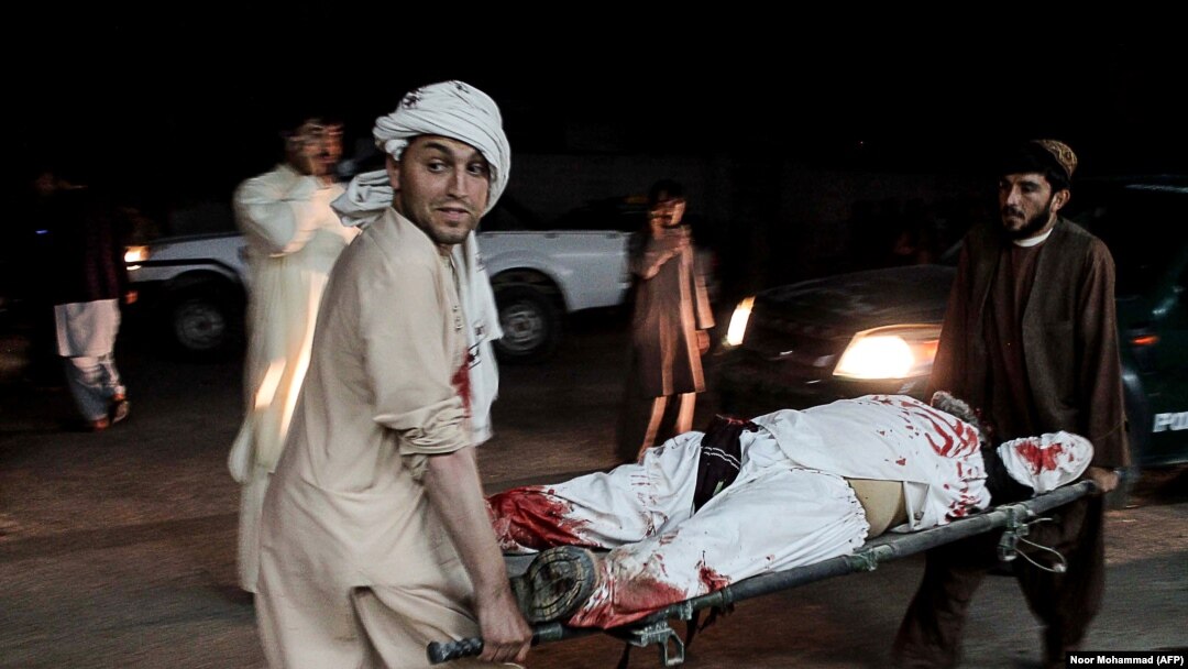A wounded man is carried on a stretcher outside a hospital following a car bomb in Lashkar Gah on March 23.