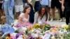 Хора оставят цветя в памет на жертвите на на стрелбата на плажа Бонди в Сидни, Австралия