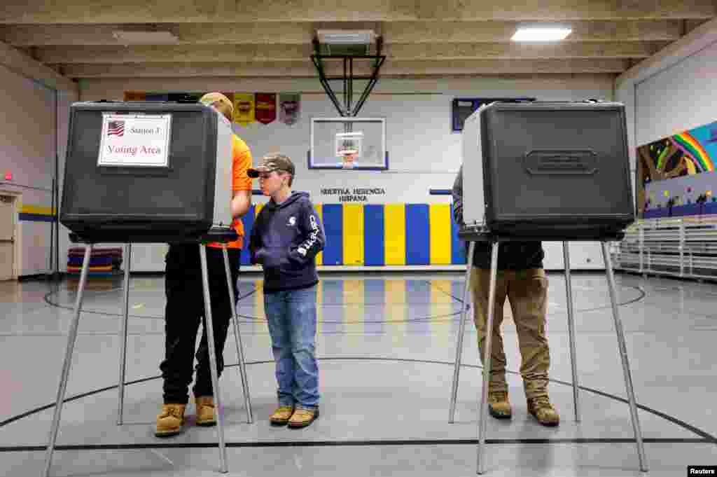 Un băiat îl urmărește pe tatăl său votând în Asheville, Carolina de Nord. &nbsp; 