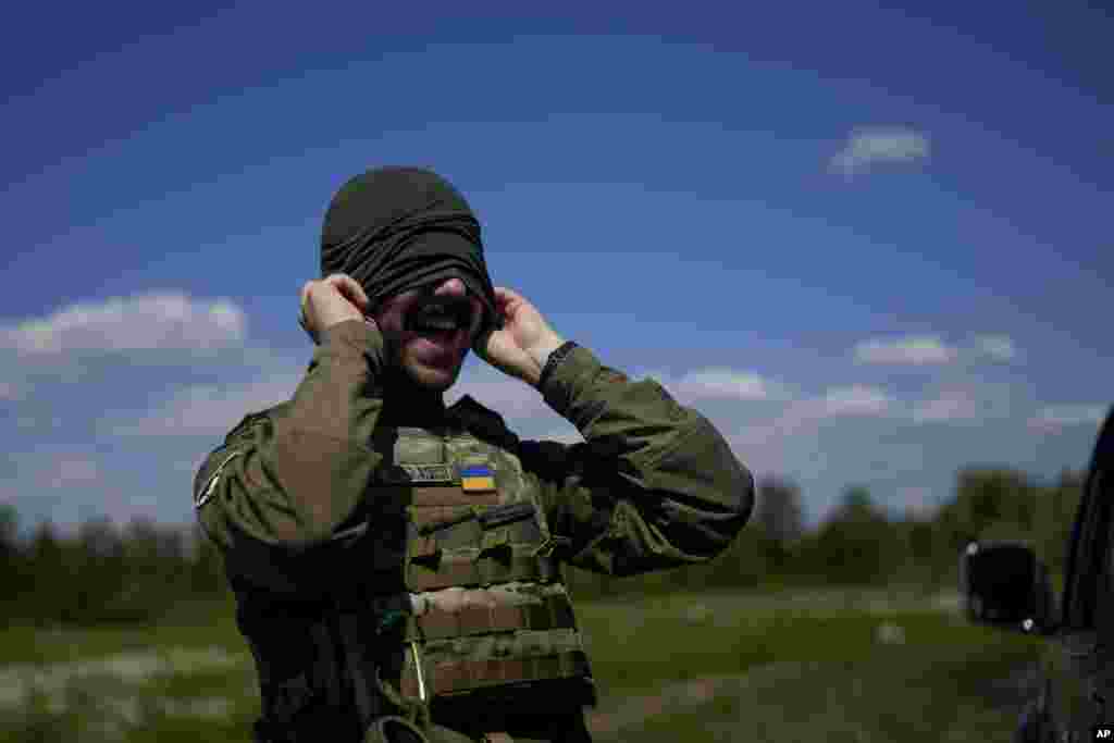 A rapperből lett katona maszkot húz a kiképzés előtt Kijev külvárosában