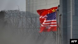 Flamuri i Kinës dhe i SHBA-së të vendosur në hyrje të një kompanie në Pekin. Fotografi ilustruese nga arkivi. 
