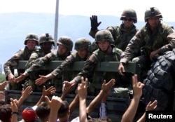Trupat amerikane duke përshëndetur shqiptarët e Kosovës më 13 qershor 1999, teksa ushtarët kalojnë pranë Kampit të Stankovecit në Maqedoninë e Veriut dhe nisen drejt Kosovës.
