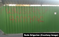 Graffiti on temporary fencing around the Phys-Gorodok construction site that says “Let's liberate Gorodok.”