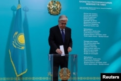 Президент Казахстана Касым-Жомарт Токаев опускает бюллетень в урну в день конституционного референдума. 5 июня 2022 года