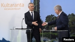 Finnish President Sauli Niinisto (right) and NATO Secretary-General Jens Stoltenberg shake hands at a press conference in Naantali, Finland, on June 12.