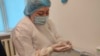 Медработник показывает ампулу с вакциной Pfizer в прививочном пункте в Алматы. 12 ноября 2021 года