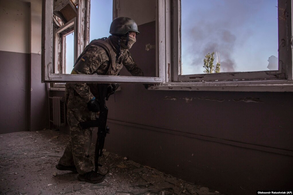 Një ushtar ukrainas shikon betejën që po zhvillohet poshtë tij në qytetin Severodonjeck.