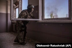 A Ukrainian serviceman views the battle unfolding below him in the city of Syevyerodonetsk.