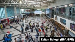 Пассажиры стоят в очереди перед стойками регистрации в международном аэропорту Будапешта, Венгрия, иллюстрационное фото