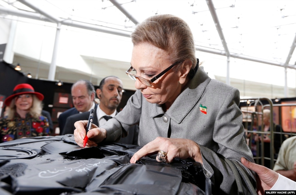Farah firma un autografo mentre visita una fiera d'arte contemporanea a Monaco nell'aprile 2013. 