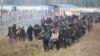 A group of migrants moves along the Belarusian-Polish border toward a camp to join those gathered at the spot and aiming to enter EU member Poland, in the Hrodna region on November 12.