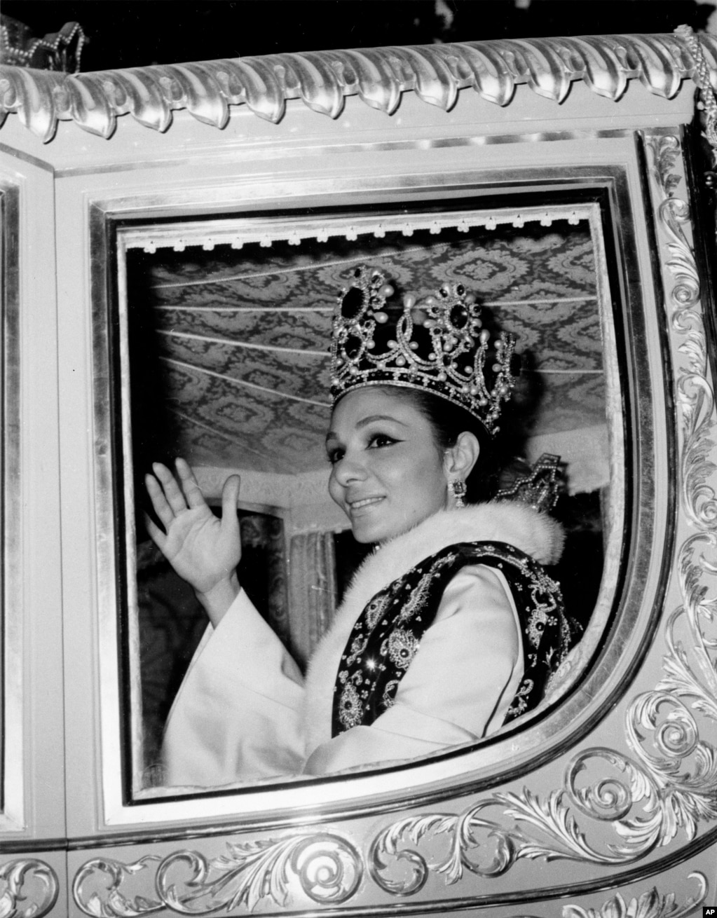 L'imperatrice Farah, moglie dello Scià dell'Iran, è raffigurata con indosso la corona mentre saluta la folla mentre guida per le strade di Teheran dopo la cerimonia di incoronazione il 26 ottobre 1967. 