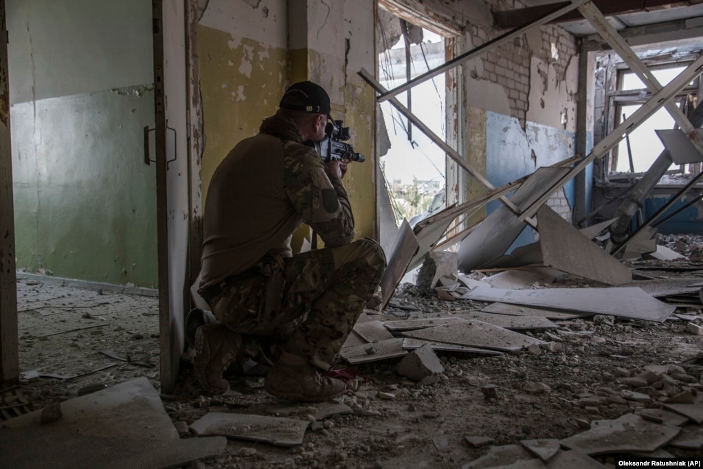 Një ushtar ukrainas duke shikuar objektivat në fushën e betejës në Severodonjeck. 