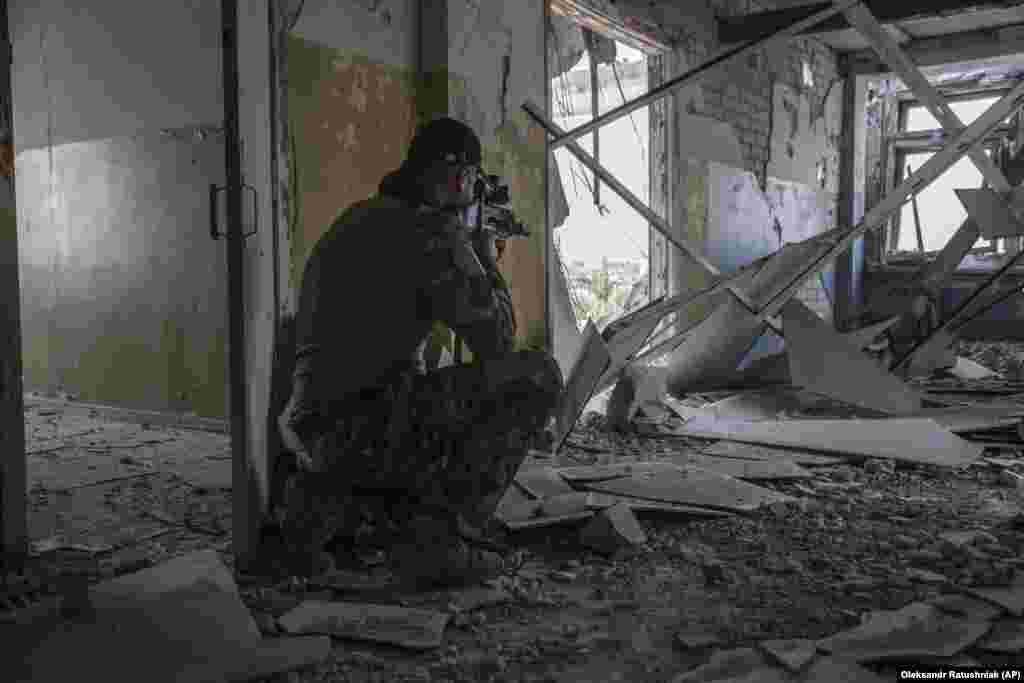 A Ukrainian serviceman uses a scope to search for targets on the battlefield in Syevyerodonetsk.