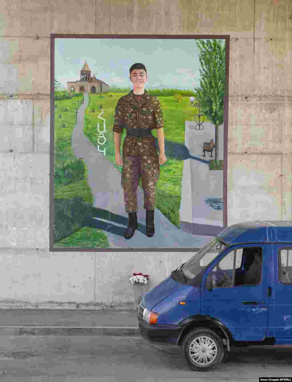 A mural in southern Yerevan accompanied with a large vase of flowers honoring a young soldier named Hayk.&nbsp; &nbsp;