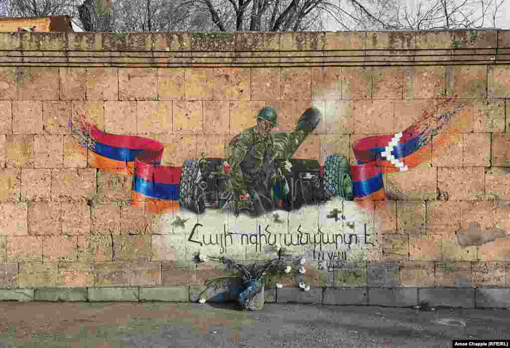 A mural in Yerevan with the combined flags of Armenia (left) and the disputed territory of Nagorno-Karabakh with script proclaiming &quot;The Armenian spirit is unbreakable.&quot;&nbsp; This image is based on a famous photo made early in the 2020 conflict of a young artilleryman called Albert Hovhannisian&nbsp;who was killed shortly after his photos were widely shared across social media.&nbsp;