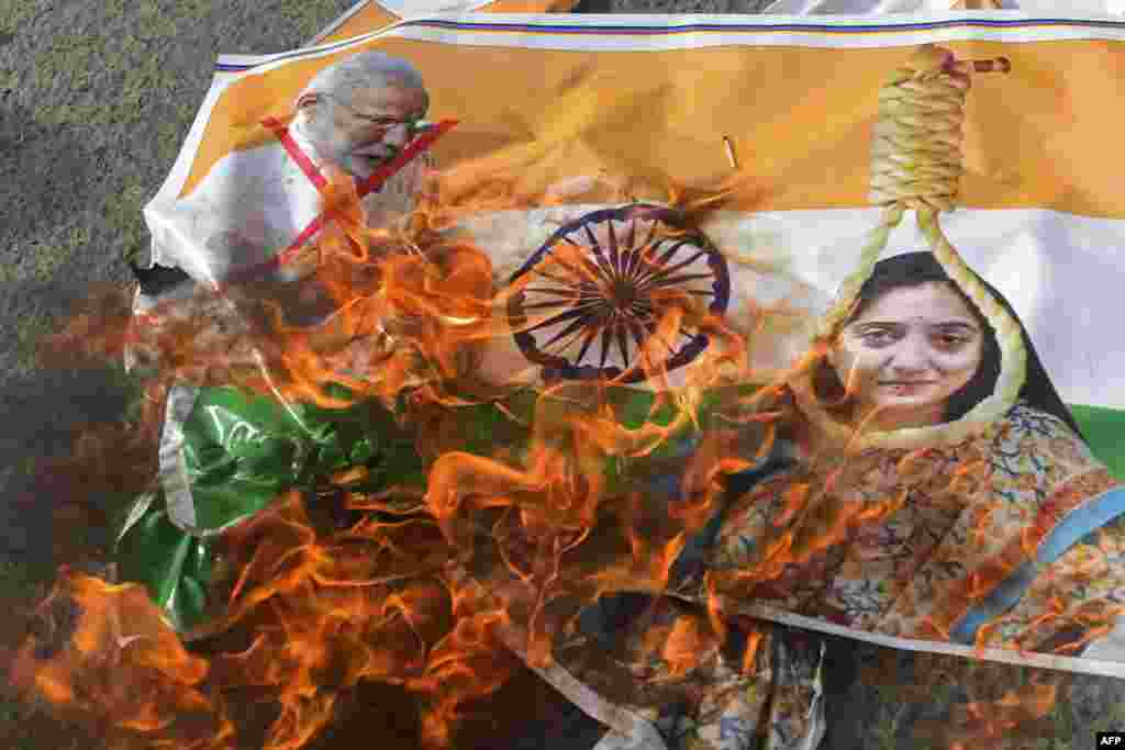 Protestors burn a poster with pictures of Indian Prime Minister Narendra Modi and former Bharatiya Janata Party spokeswoman Nupur Sharma during a demonstration over her remarks on the Prophet Muhammad, in Karachi on June 9, 2022.