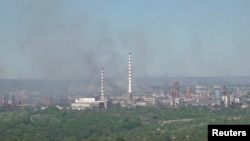 Black smoke billows over the Azot chemical plant in Syevyerodonetsk in this still image obtained from a handout video released on June 9. 