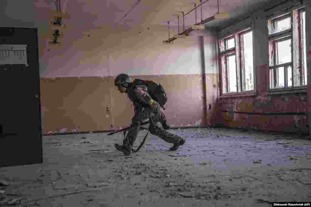 A Ukrainian serviceman runs for cover.