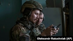 Soldați ucraineni se uită la ecranul unei drone care arată pozițiile trupelor rusești în timpul luptelor grele de pe linia frontului din Severodonețsk, regiunea Luhansk, Ucraina, miercuri, 8 iunie 2022.