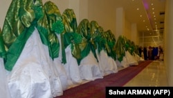 Brides stand inside a wedding hall as they wait for the start of a mass marriage ceremony in Kabul in June.