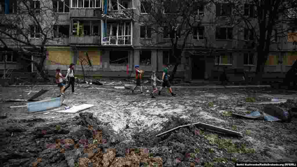 Gyerekek sétálnak el egy becsapódott rakéta maradványai mellett. Bahmut 55 kilométerre délre fekszik Liszicsanszktól és Szeverodonyecktől, ahol intenzív harcok folynak. Ez&nbsp;Kijev szerint&nbsp;&bdquo;az egyik legbrutálisabb csata Európában és Európáért&rdquo;