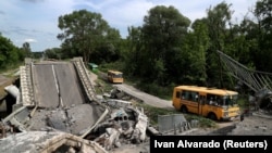 An evacuation convoy travels from the Russian-occupied town of Kupiansk along a damaged road on the outskirts of Kharkiv on May 30.