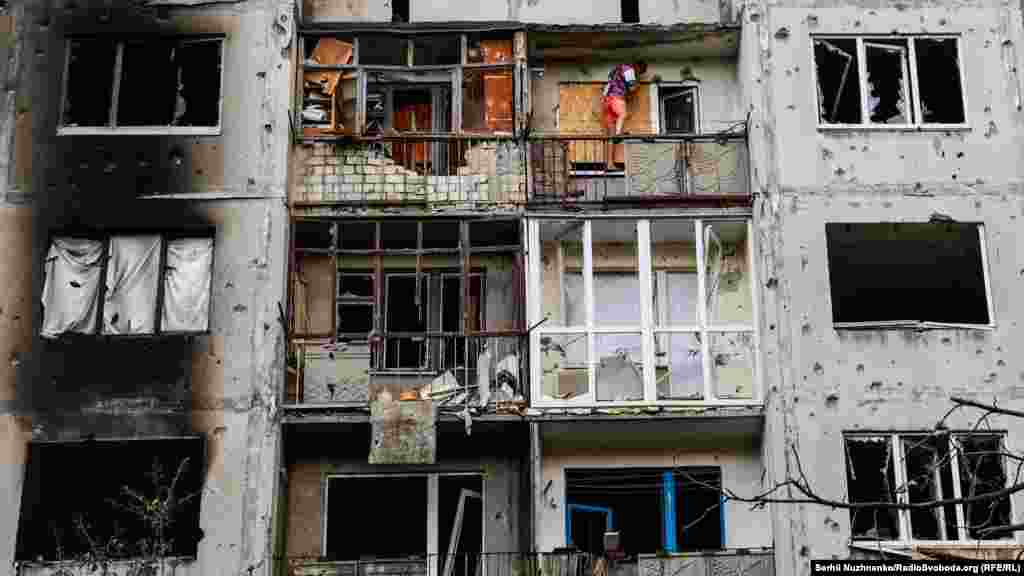 Мужчина забивает окно фанерой после российского обстрела. Бахмут, 13 июня 2022 года