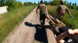 Ukrainian combat medics carry wounded soldier on a stretcher