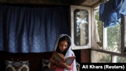 Egy afgán lány könyvet olvas otthonában, Kabulban, Afganisztánban 2022. június 13-án