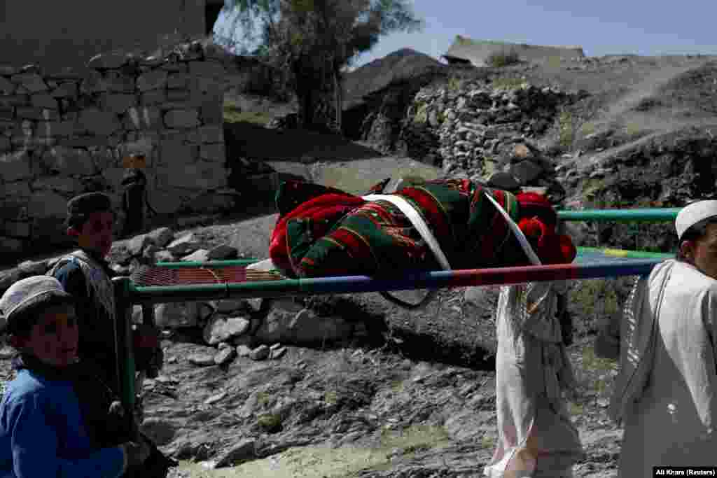 Afghan boys carry the body of a child who was killed in the Golam Kot district in Paktika Province.&nbsp;