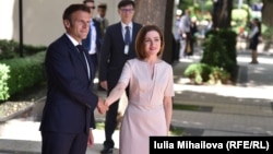 French President Emmanuel Macron (left) shakes hands with Moldovan President Maia Sandu in Chisinau on June 15.